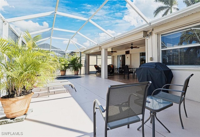 view of patio / terrace featuring ceiling fan, area for grilling, and glass enclosure