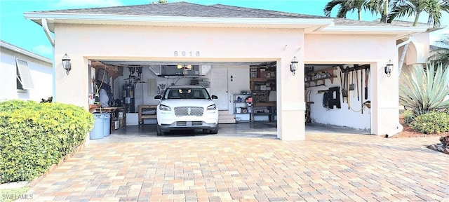 garage with decorative driveway and electric water heater