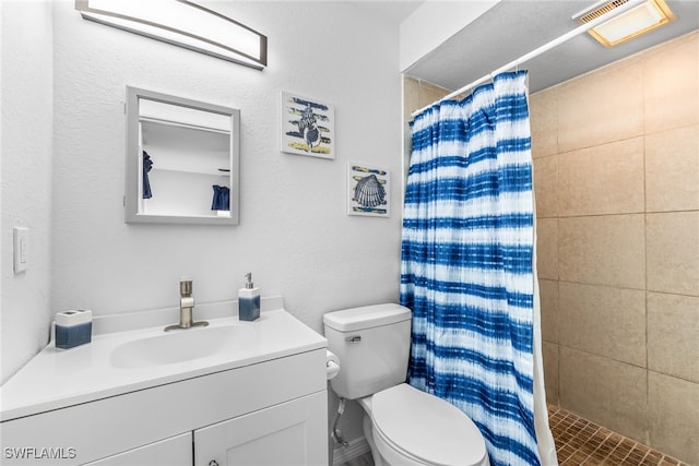 bathroom featuring toilet, a shower stall, and vanity