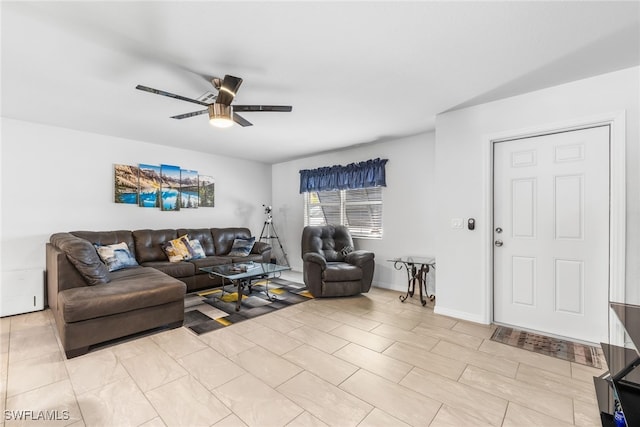 living room featuring a ceiling fan and baseboards