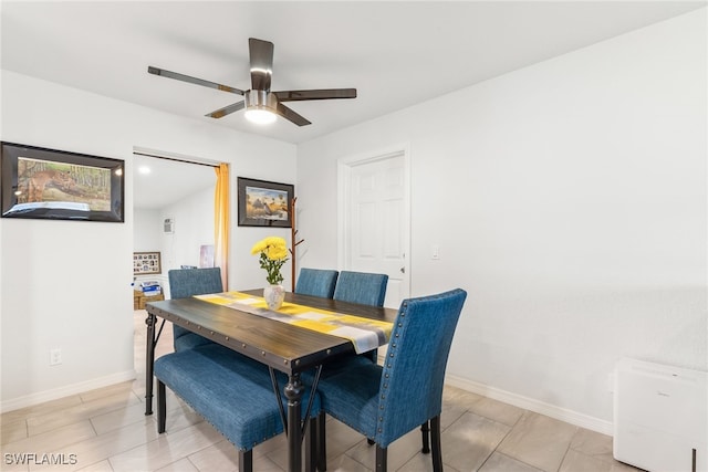 dining space with baseboards and a ceiling fan