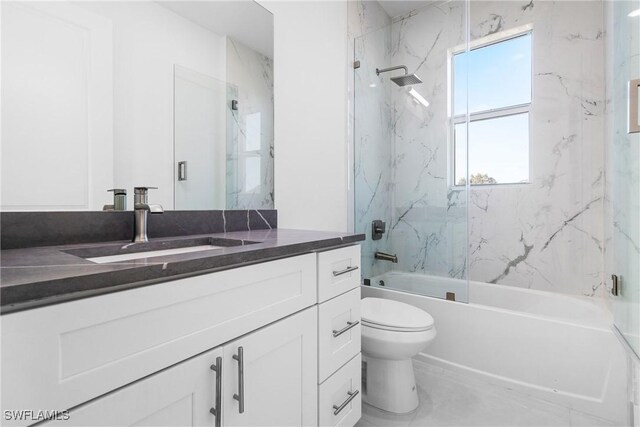 full bathroom featuring tiled shower / bath, vanity, and toilet