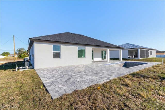 back of property with a pool, a yard, and a patio area