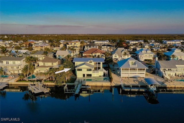 aerial view at dusk featuring a water view