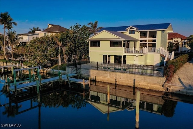 rear view of property featuring a water view and a balcony