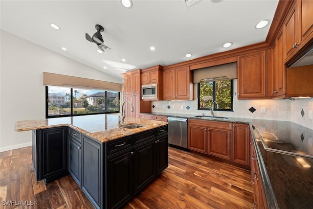 18292 Deep Passage Ln, Fort Myers Beach, FL 33931 - kitchen featuring stainless steel appliances, vaulted ceiling, a sink, tasteful backsplash, and dark wood finished floors