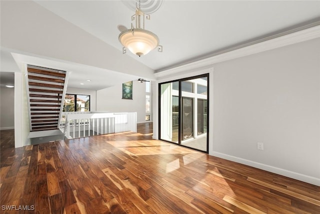 spare room featuring baseboards, wood finished floors, and lofted ceiling