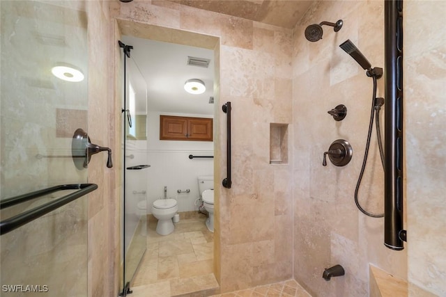 bathroom featuring a shower with door and toilet