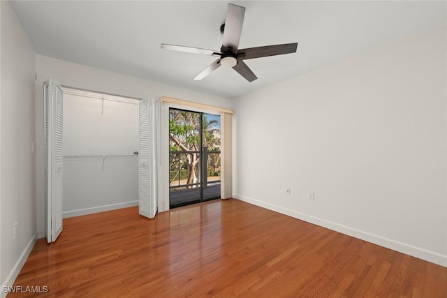 unfurnished bedroom featuring hardwood / wood-style floors, access to outside, a closet, and ceiling fan