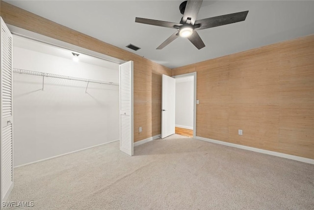 unfurnished bedroom with ceiling fan, a closet, and light carpet