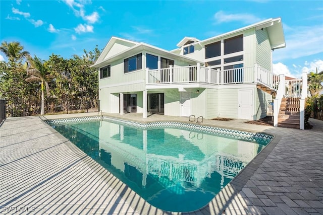 18292 Deep Passage Ln, Fort Myers Beach, FL 33931 - back of house featuring stairs, a patio, an outdoor pool, and a balcony