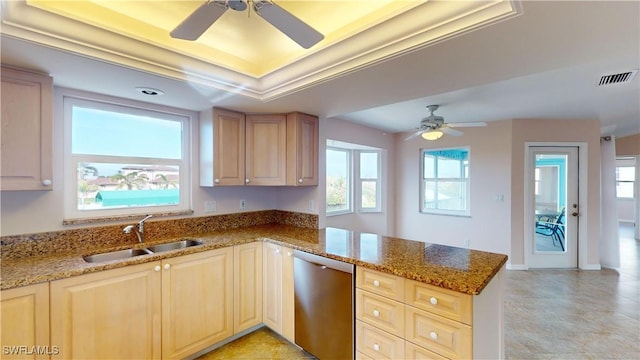 kitchen featuring a raised ceiling, dishwasher, sink, and kitchen peninsula