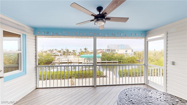 sunroom / solarium featuring a water view and ceiling fan