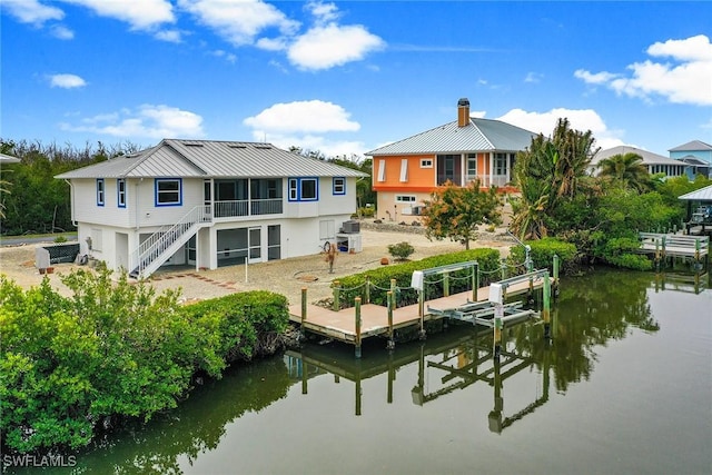 back of property with a water view, central AC, and a sunroom