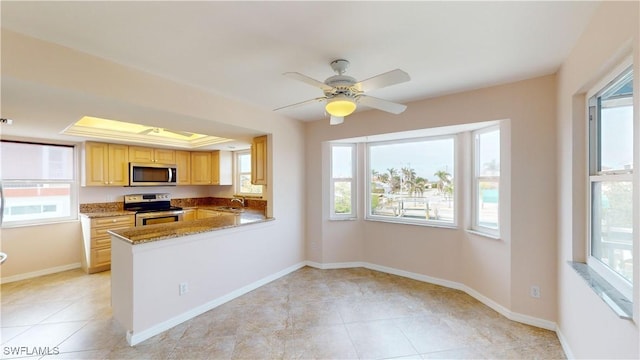 kitchen with light brown cabinetry, sink, kitchen peninsula, a raised ceiling, and stainless steel appliances