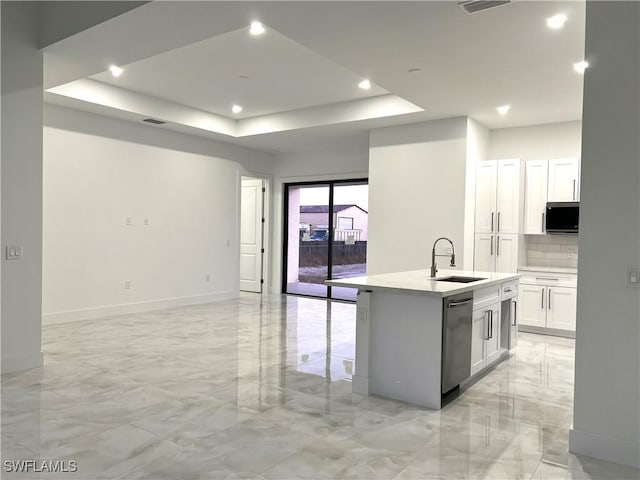 kitchen featuring sink, white cabinets, a center island with sink, stainless steel dishwasher, and a raised ceiling