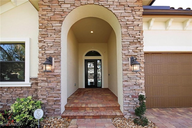 entrance to property featuring stone siding and stucco siding