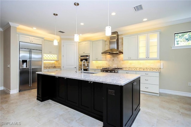 kitchen with visible vents, a large island, stainless steel appliances, wall chimney range hood, and a sink