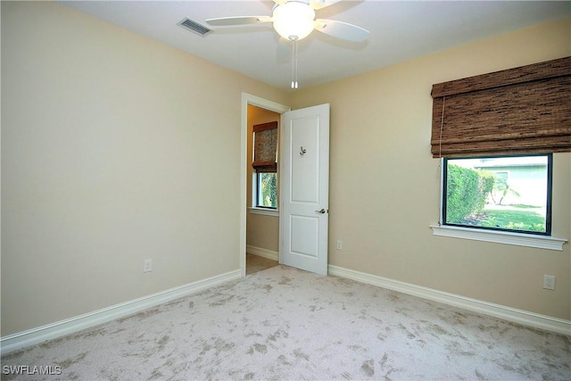 spare room featuring a ceiling fan, carpet, visible vents, and baseboards