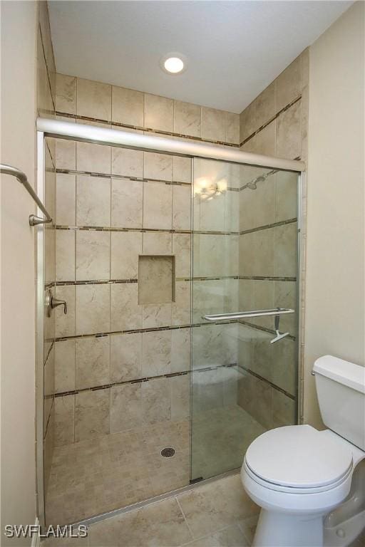 bathroom featuring toilet and a stall shower