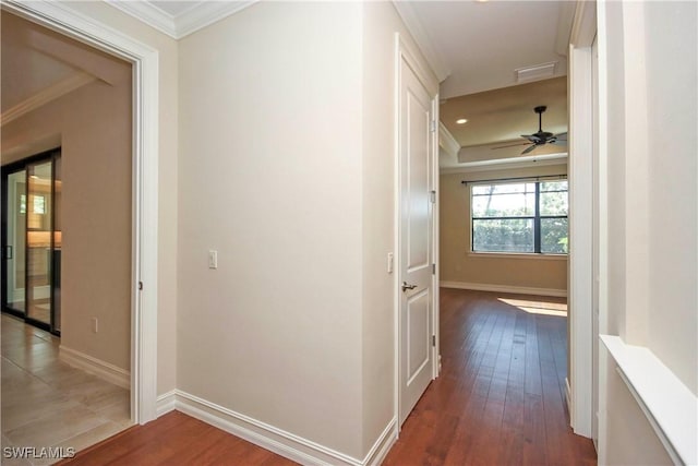 corridor with baseboards, wood finished floors, and crown molding