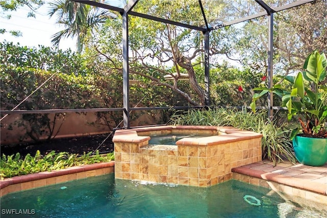 view of swimming pool featuring a lanai and an in ground hot tub