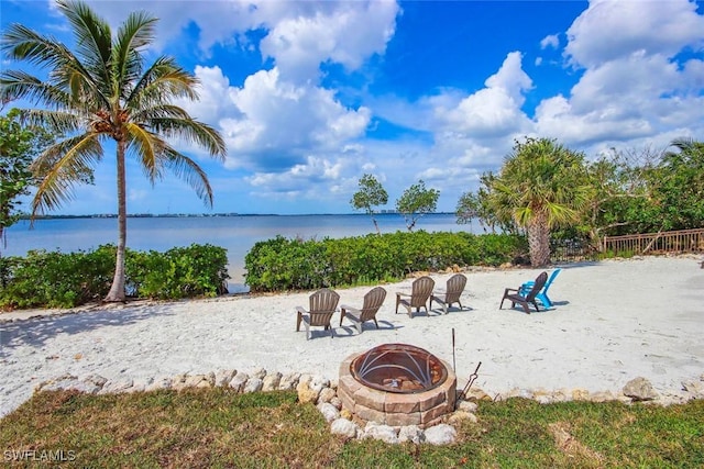 view of property's community with a water view and a fire pit