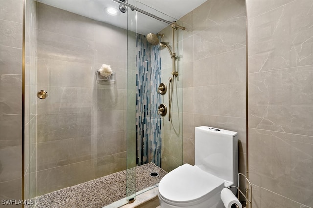 bathroom featuring a tile shower, tile walls, and toilet