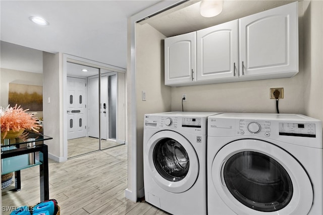 clothes washing area featuring light hardwood / wood-style floors, washing machine and dryer, and cabinets