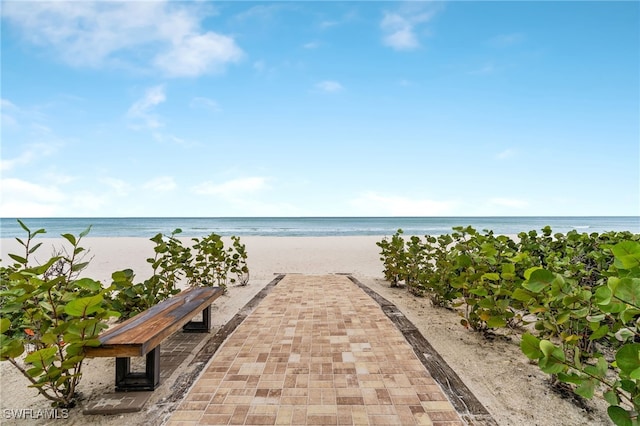 view of property's community with a water view and a beach view