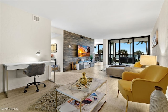 living room with expansive windows and light hardwood / wood-style flooring