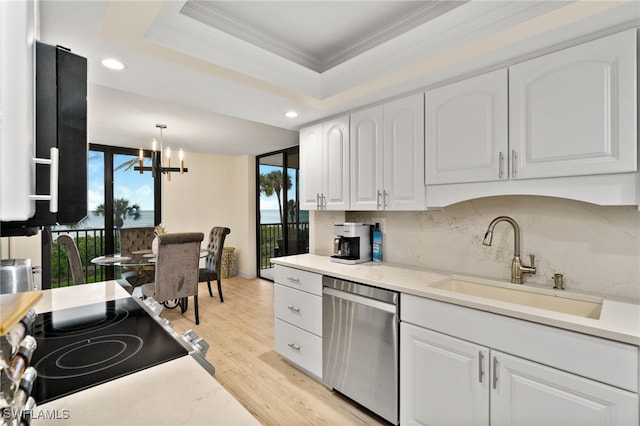 kitchen with sink, a tray ceiling, white cabinets, decorative light fixtures, and stainless steel dishwasher