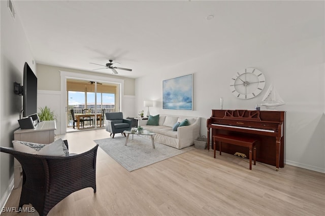 living room with light hardwood / wood-style floors and ceiling fan