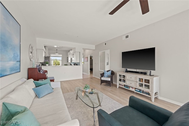 living room with ceiling fan and light hardwood / wood-style flooring