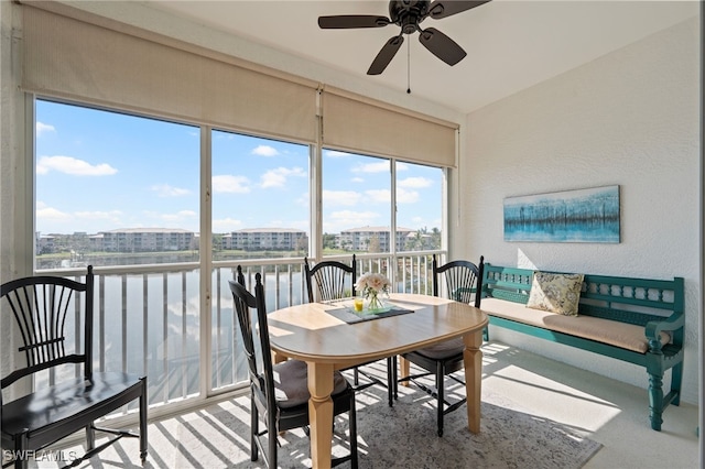 sunroom featuring a water view