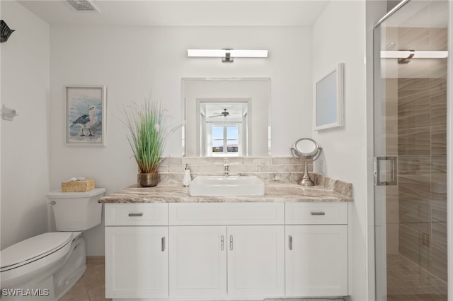 bathroom with tile patterned flooring, vanity, toilet, and an enclosed shower