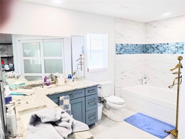 bathroom with vanity, a bathtub, and toilet