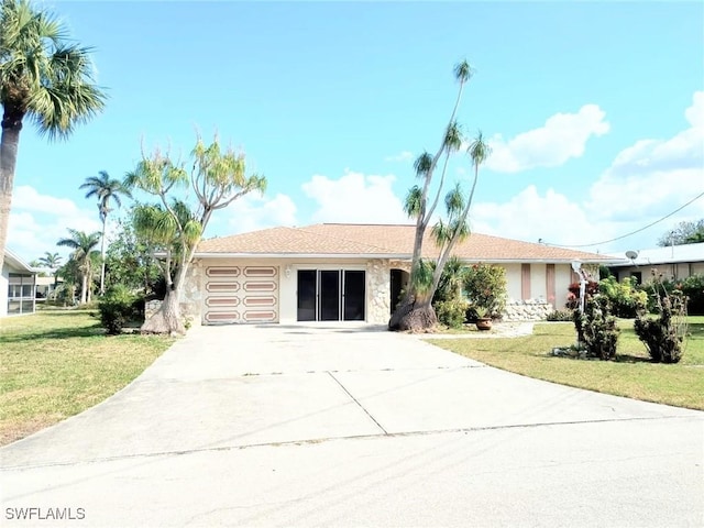 single story home featuring a garage and a front yard