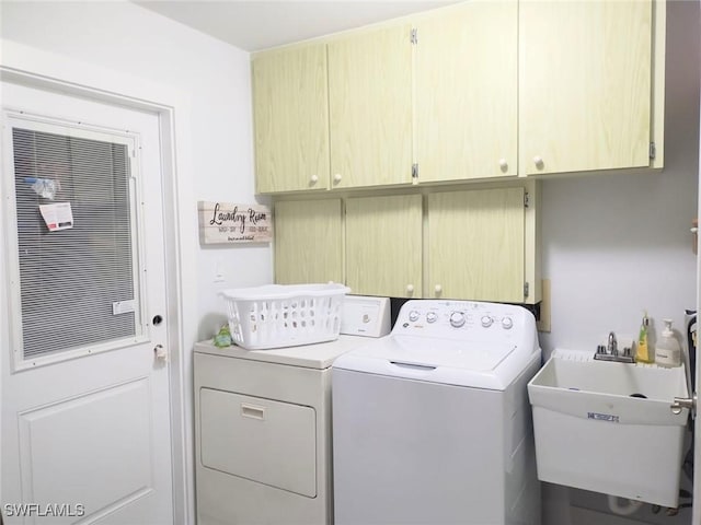 laundry room featuring sink, washing machine and dryer, and cabinets