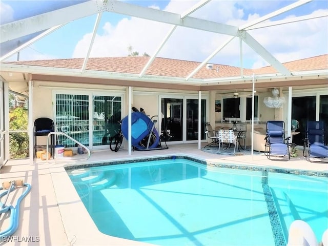 view of swimming pool featuring a lanai, ceiling fan, and a patio area