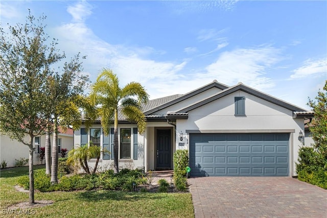 ranch-style home with a garage, a front yard, decorative driveway, and stucco siding