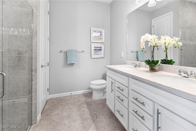 full bathroom with double vanity, a shower stall, tile patterned floors, and a sink