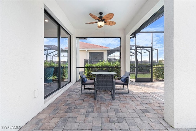 sunroom / solarium featuring outdoor dining space and ceiling fan