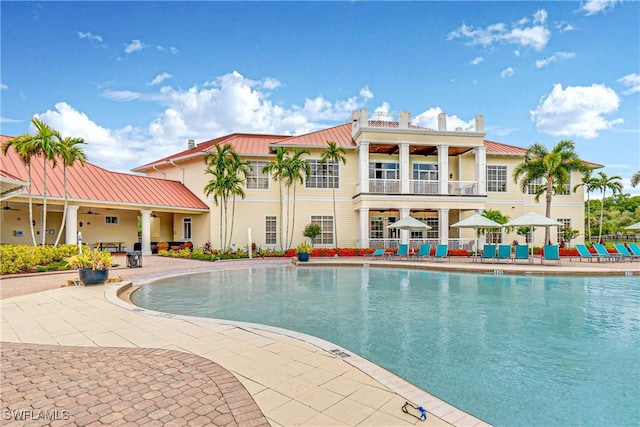 community pool with a ceiling fan and a patio