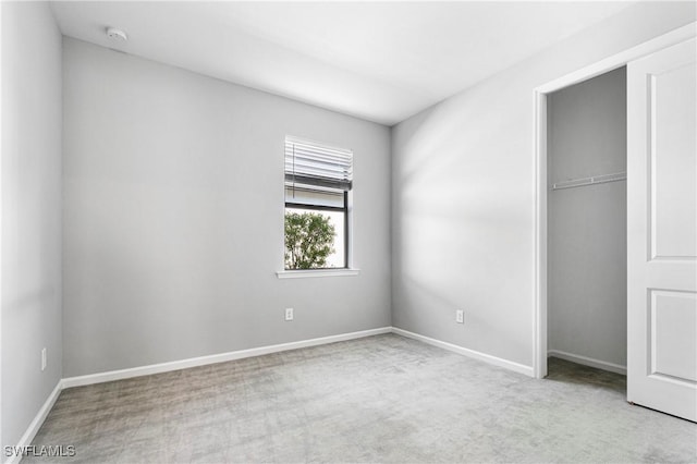 unfurnished bedroom featuring baseboards, carpet flooring, and a closet