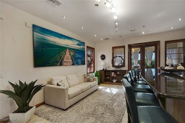 living area featuring recessed lighting, visible vents, baseboards, and french doors