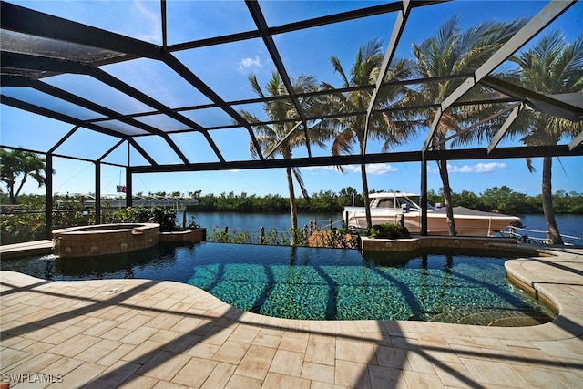 view of pool with a pool with connected hot tub, glass enclosure, a water view, and a patio