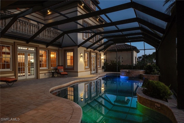 view of swimming pool featuring a pool with connected hot tub, french doors, glass enclosure, and a patio