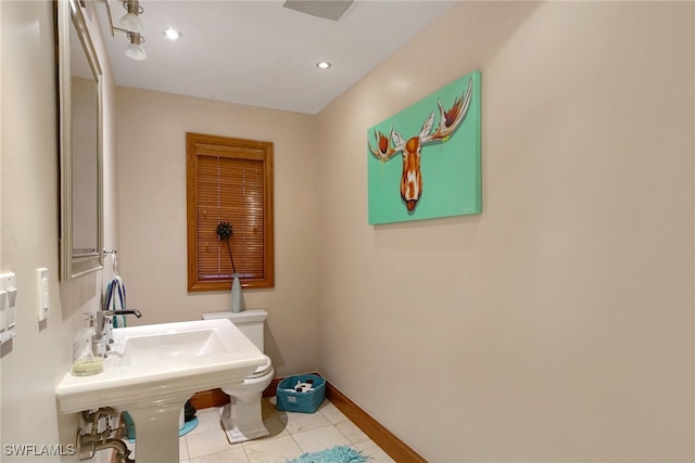 half bath featuring recessed lighting, toilet, a sink, tile patterned flooring, and baseboards