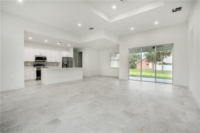 unfurnished living room featuring a tray ceiling